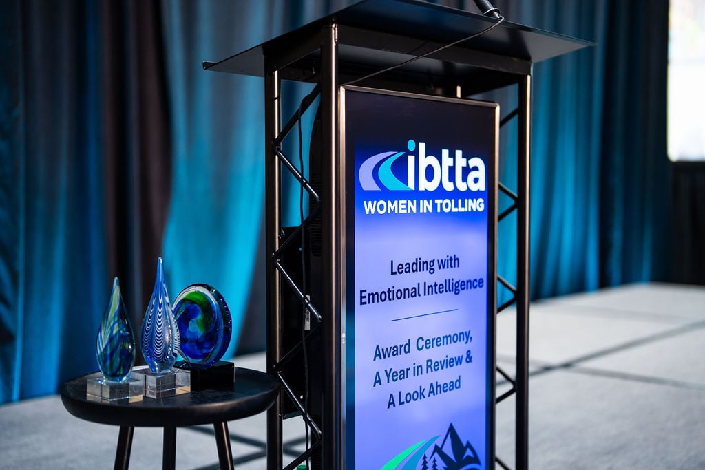 A lecturn with IBTTA Women in Tolling logo