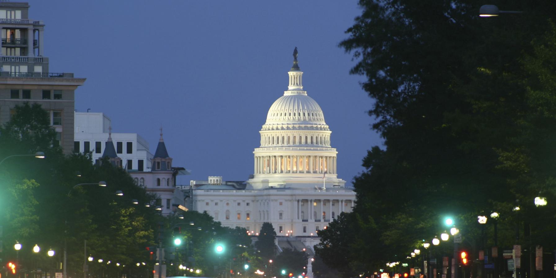 U.S. Capitol at night with cars on street