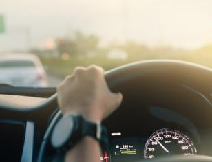 hands on steering wheel with view of roadway