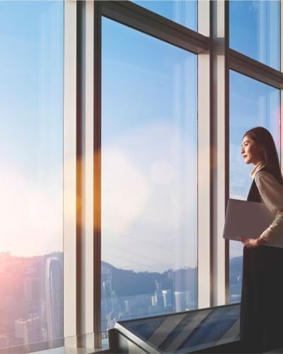 woman holding a folder looking out of a window