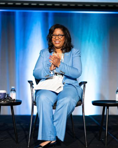 Joi Taylor Dean sitting in a chair clapping